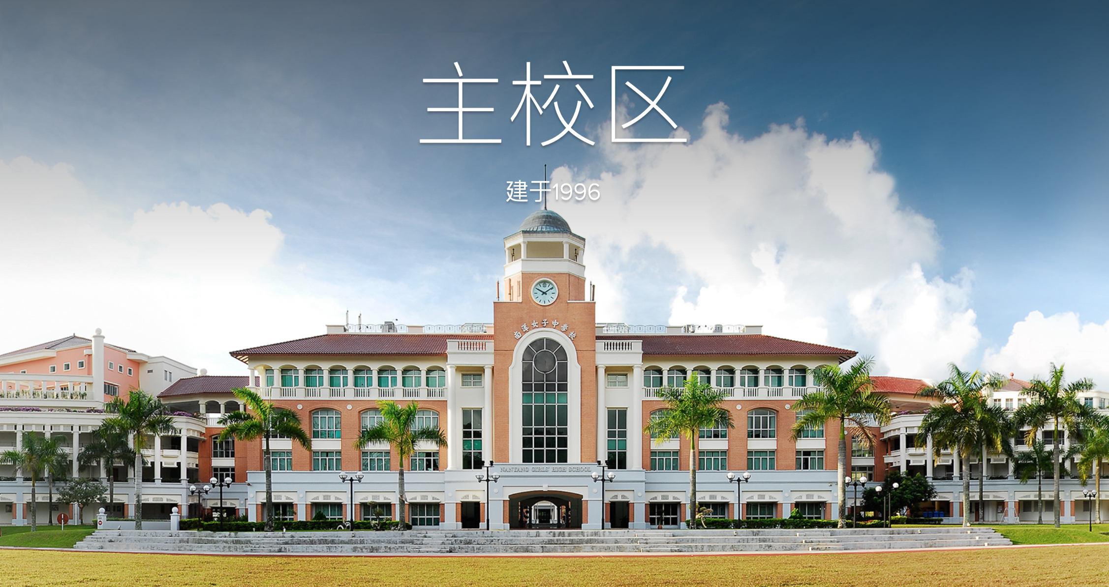 Large school building with a central clock tower and palm trees; Chinese text reads Main Campus, built 1996